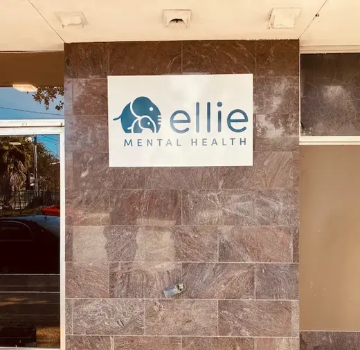 Signage for Ellie Mental Health, an intensive outpatient program in Galveston, displayed on a stone wall.
