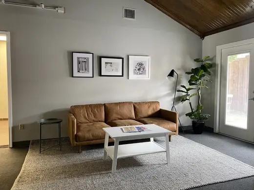 Cozy living room with leather couch at Lighthouse Recovery Texas, an intensive outpatient program in Galveston.