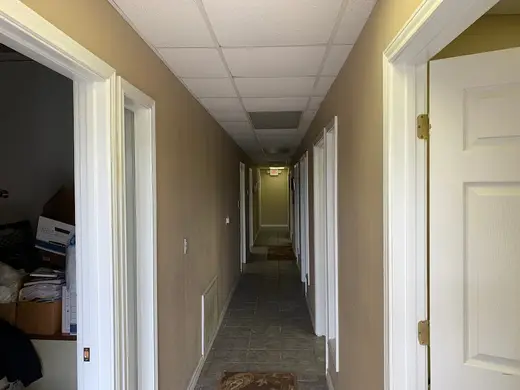 Bright hallway with doors leading to rooms at ADAPT Programs - Angleton, an intensive outpatient program in Galveston.