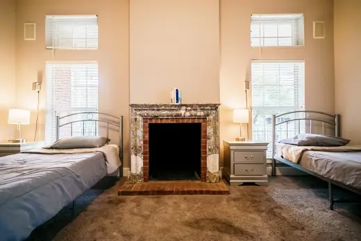 Cozy bedroom with two beds at Discovery Point Retreat, a sober living home in Galveston.