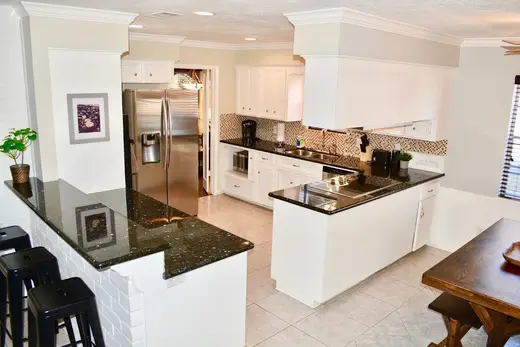 Modern kitchen with granite countertops at Bodine Recovery, a sober living home in Galveston.